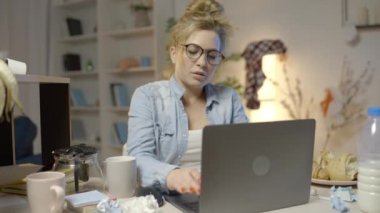 Tükenmiş kadın serbest çalışan, projesinin bitmesinden mutlu, dizüstü bilgisayarını kapatıyor.