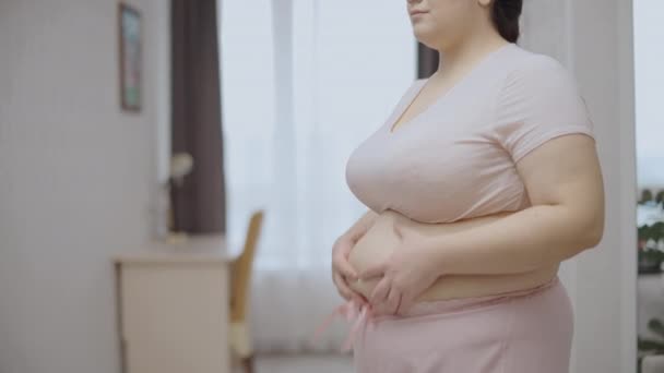 伤心欲绝的年轻女子摸着肚子上的脂肪卷 健康问题 饮食失调 — 图库视频影像