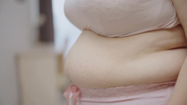 プラスサイズ女性タッチ過剰な腹部脂肪感不幸な — ストック動画