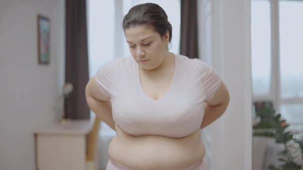 測定テープを見て動揺オーバーサイズの女性 ウエストラインの周りの脂肪 体重減少 — ストック動画