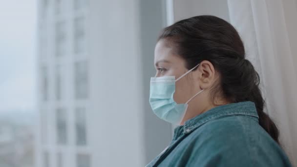 ウィンドウの近くに立って保護マスクでブルネット女性 ウイルス性疾患 Covid — ストック動画