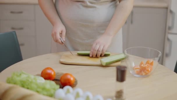 家庭主妇在切菜板上切有机黄瓜 烹调素食沙拉 — 图库视频影像
