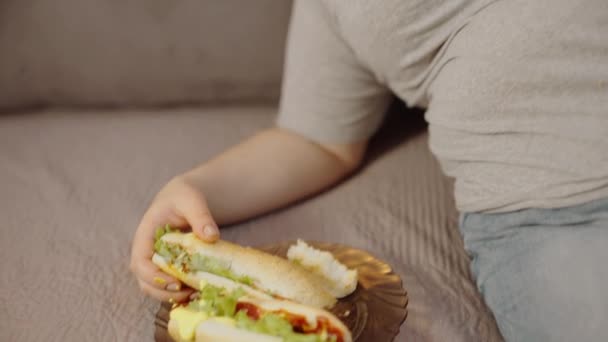 肮脏的肥胖女性睡在沙发上 手里拿着三明治 混乱的生活方式 — 图库视频影像