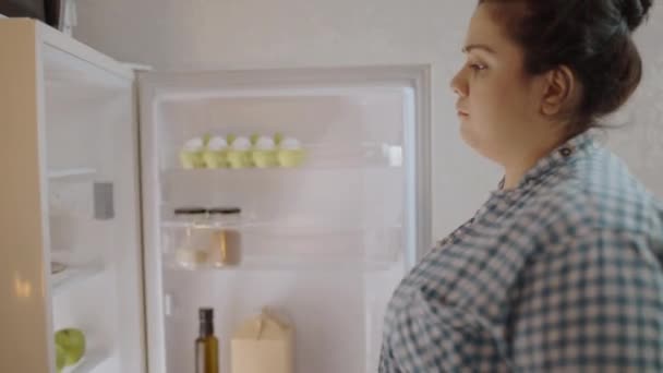 Przemyślana Młoda Kobieta Patrząca Lodówce Nawyki Żywieniowe Przyrost Masy Ciała — Wideo stockowe