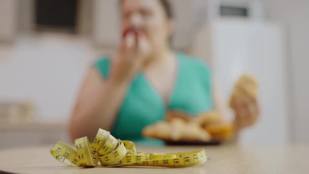 Gul Måttband Bordet Med Hungrig Överviktig Kvinna Äter Bakgrunden — Stockvideo