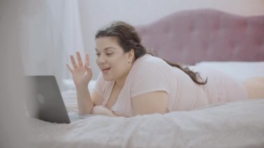 Mutlu artı beden kadın arkadaşınla internette konuşuyor, yatakta yatıyor, internette...
