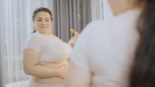 Satisfied Overweight Woman Eating Cake Front Mirror Feeling Beautiful — Stock Video
