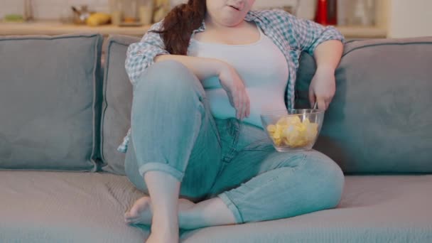 Τεμπέλικη Παχύσαρκη Γυναίκα Τρώει Τσιπς Αλλάζει Κανάλια Στην Τηλεόραση Καθιστική — Αρχείο Βίντεο
