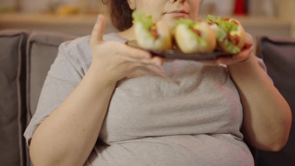Толстая Женщина Любуется Нездоровыми Хот Догами Тарелке Вредной Пищевой Зависимостью — стоковое видео