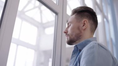 Düşünceli genç adam pencereden şehre bakıyor. Karar veriyor, sorun var.