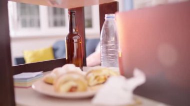 Kirli bir dairede dizüstü bilgisayarın önünde uyuyan pis bekar, iş yerinde kaos.