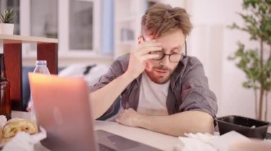 Saplantılı programcı kirli masada uyanıyor, dizüstü bilgisayarda yazıyor, işkolik.