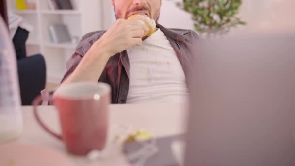 Soltero Desordenado Comiendo Limpiando Mano Sucia Camiseta Viendo Videos Línea — Vídeo de stock