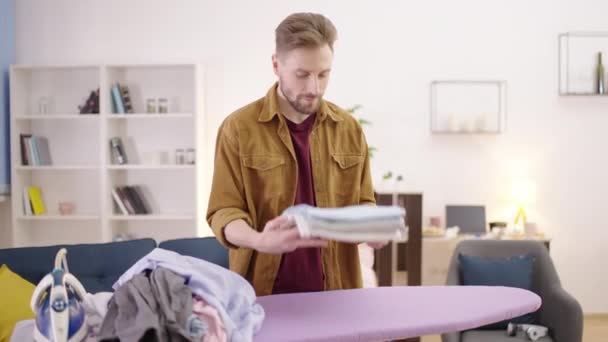男人拿着一堆折叠的衣服 男性完美主义者喜欢做家务 — 图库视频影像