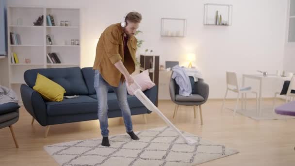 用吸尘器跳舞 在家里擦地毯 玩乐的年轻人 — 图库视频影像
