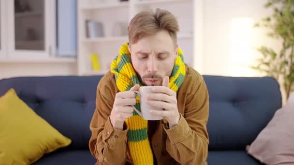 Młody Mężczyzna Pijący Gorącą Herbatę Domu Uczucie Zimna Objaw Bólu — Wideo stockowe