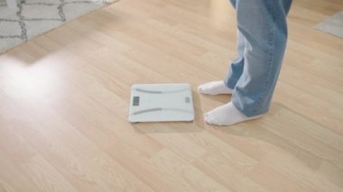 Kotlu adam terazinin üzerinde duruyor, aşırı vücut yağı, yavaş metabolizma.