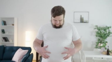 Depresyondaki şişman adam göbeğine dokunuyor, fiziksel hareketsizlik, güvensizlik.