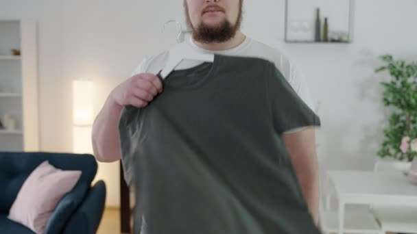 Zdenerwowany Oversize Mężczyzna Patrząc Mały Shirt Problem Odchudzaniem Wygląd — Wideo stockowe