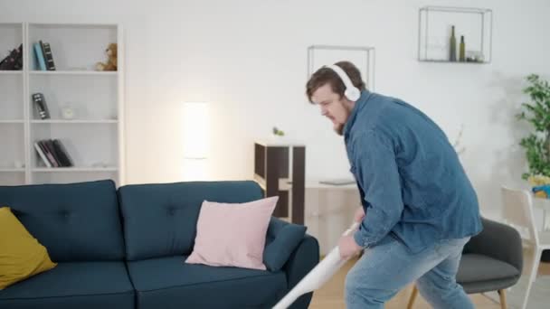 Inspired Overweight Man Vacuuming Carpet Listening Radio Headphones — Stock Video