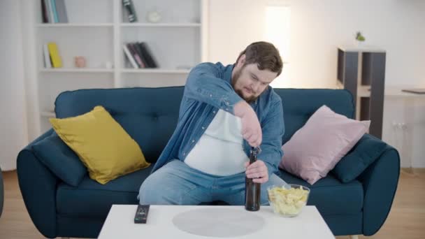 Obese Man Opent Glazen Fles Bier Drinkt Alcohol Voor Thuis — Stockvideo