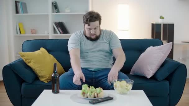 Übergewichtiger Mann Isst Hot Dog Sieht Fernsehen Sitzenden Lebensstil Junk — Stockvideo