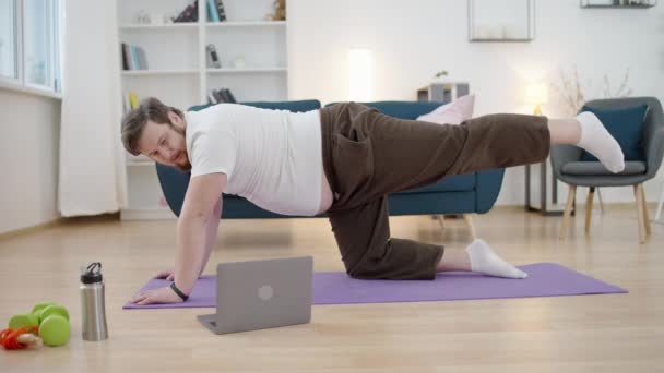 Humoroso Obeso Sexo Masculino Fazendo Pilates Casa Assistindo Vídeo Laptop — Vídeo de Stock