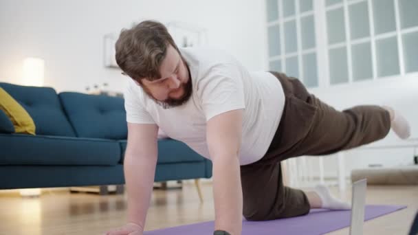 家でオンライントレーニングを行う太りすぎの男性 筋肉の強さ — ストック動画