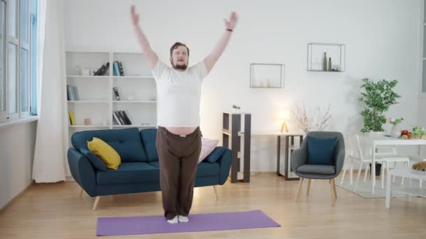 累了的体形丰满的男人跳上运动垫 在家里锻炼 — 图库视频影像