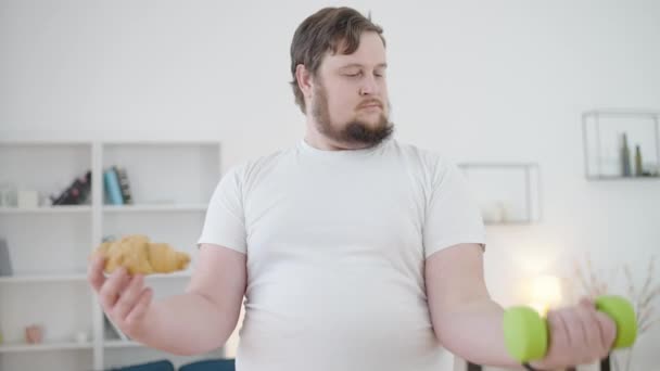 Glücklicher Fettleibiger Mann Der Hantel Hebt Croissant Isst Ungesunder Lebensstil — Stockvideo