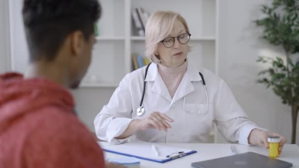 Terapeuta Dający Pacjentowi Butelkę Tabletek Przepisujących Leki Opiekę Zdrowotną — Wideo stockowe