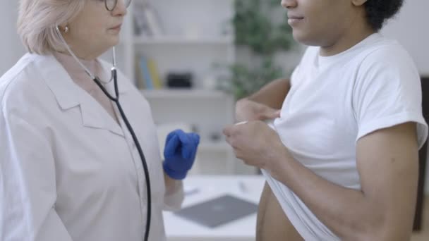 Női Orvos Vizsgálja Fiatal Férfi Sztetoszkóppal Tüdőbetegség Megelőzése — Stock videók