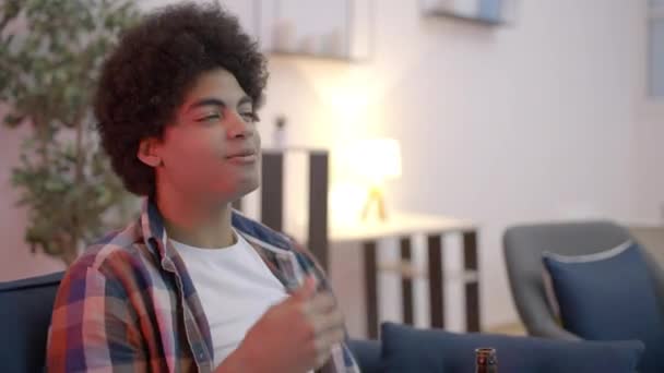 Zrelaksowany Młodzieniec Oglądający Film Kanapie Pijący Piwo Słonymi Przekąskami — Wideo stockowe