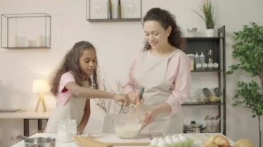 Kızının mutfakta anneme yardım etmesi, birlikte yemek pişirmesi, aile gelenekleri.