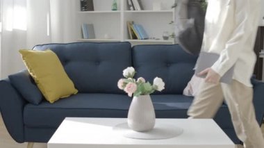 Sırt çantası fırlatan ve kanepede oturan yorgun genç kız, okulda kötü bir gün.