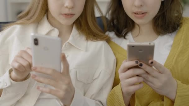 两个女性朋友在智能手机和社交媒体应用程序上打转 — 图库视频影像