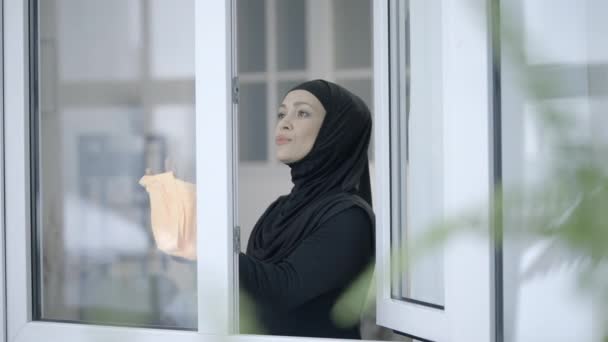 Мусульманская Домохозяйка Хиджабе Моющее Окно Стекло Спреем Уборка — стоковое видео