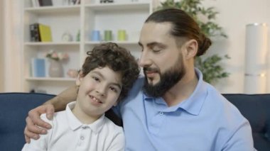Gururlu baba küçük oğlunu kucaklıyor ve kamerada gülümsüyor, çocuk yetiştirme, aile.