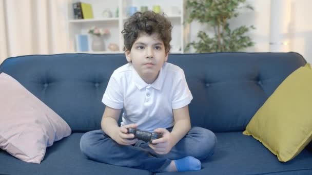 Liten Pojke Spelar Spel Med Joystick Sitter Soffan Ensam Har — Stockvideo