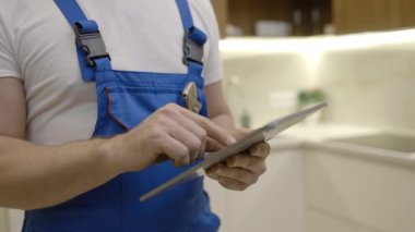Tesisatçı tablet üzerinde çalışıyor, tesisat malzemeleri sipariş ediyor, bakım...