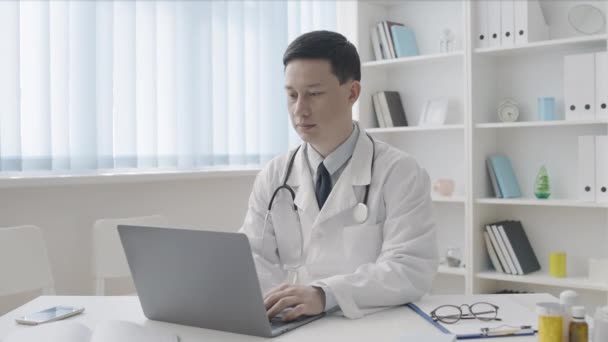 Lekarz Azjatycki Pracujący Laptopie Biurze Przyjazny Uśmiech Twarzy Opieka Zdrowotna — Wideo stockowe