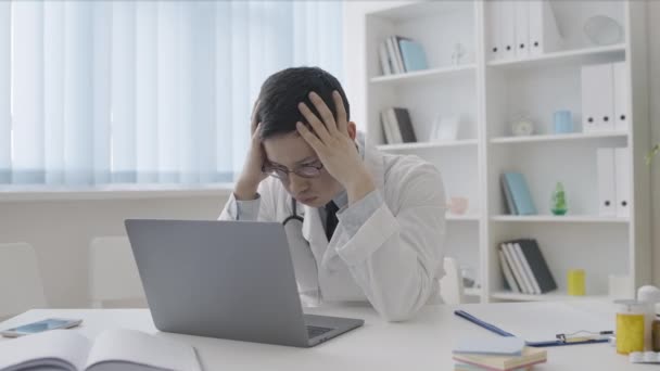 複雑な診断を考えながら頭に触れる苦痛な医療インターン — ストック動画