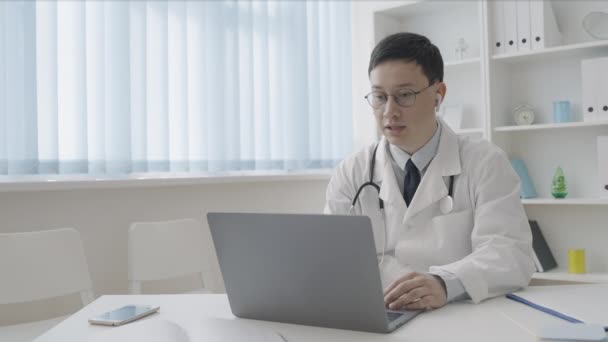 Asiatischer Hausarzt Berät Patienten Videoanruf — Stockvideo