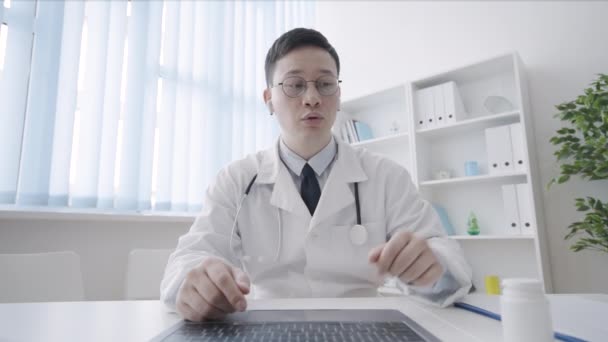 Asiatischer Therapeut Zeigt Patientin Flasche Pillen Bei Videotelefonat — Stockvideo