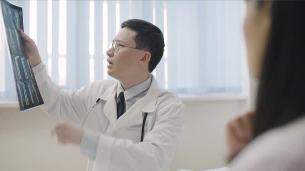 Lekarz Rehabilitacyjny Sprawdza Prześwietlenie Kości Konsultuje Rannego Pacjenta Leczy — Wideo stockowe
