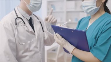 Erkek doktor, kadın stajyere hasta tedavisini öğretiyor.