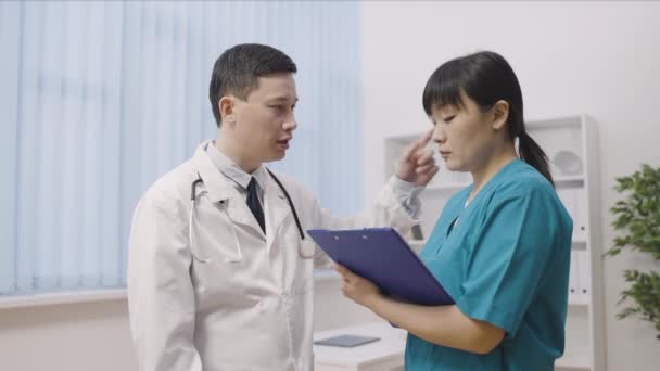Aktywny Lekarz Azjatycki Daje Instrukcje Pielęgniarce Profesjonalnemu Zespołowi Szpitalowi — Wideo stockowe