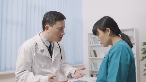 Verärgerte Männliche Arzt Schimpft Asiatische Krankenschwester Problem Bei Der Arbeit — Stockvideo