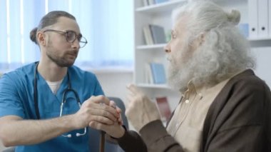 Yaşlı adam huzurevinde doktorla konuşuyor, yaşlılar için tıbbi bakım, destek...