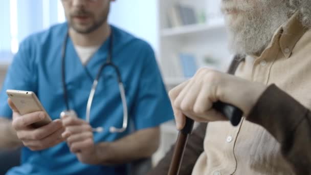 Operatore Medico Che Mostra App Smartphone Pensionato Cura Del Compagno — Video Stock